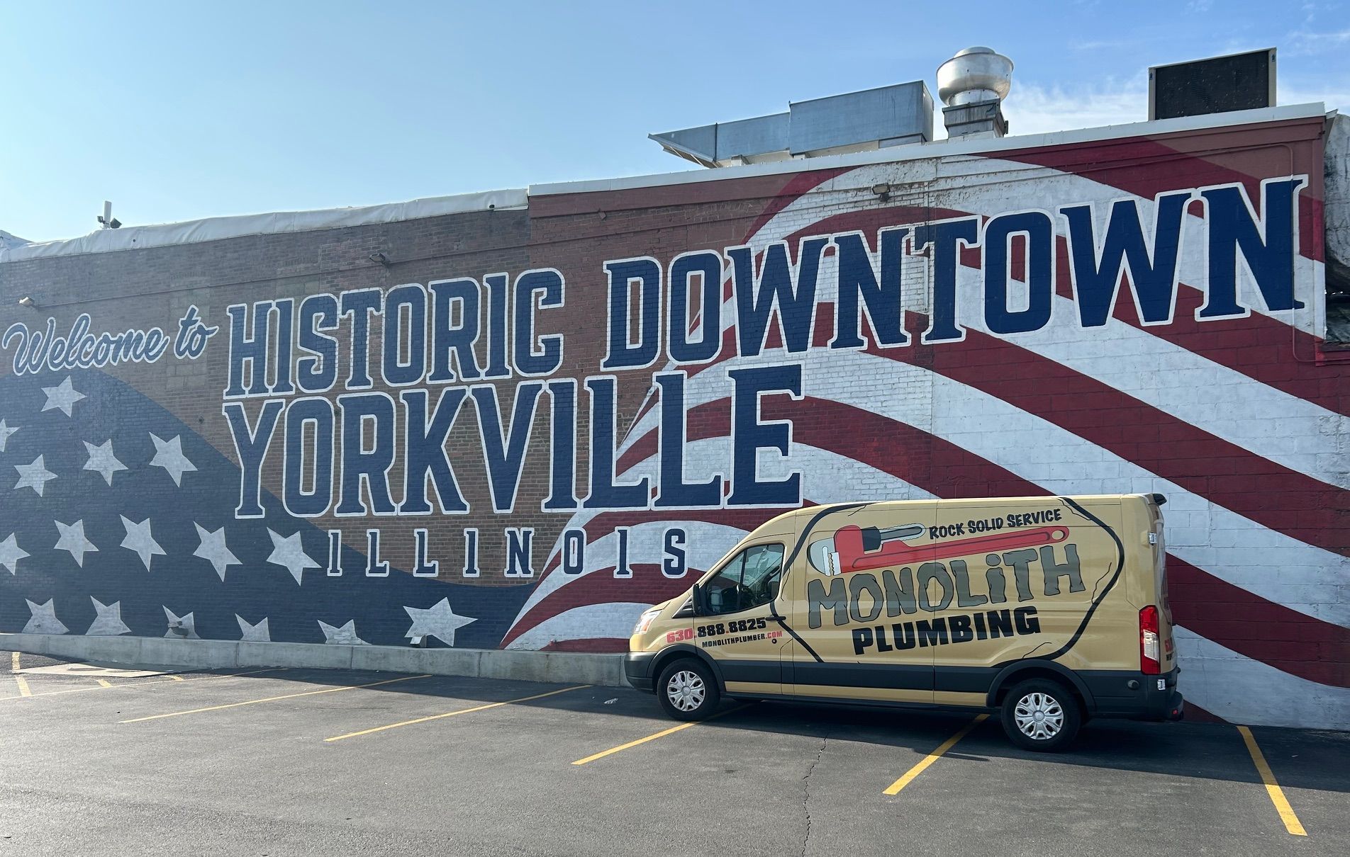 Person working on pipes with a wrench, likely a plumber fixing heating equipment.