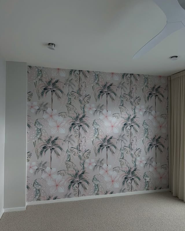 Wall with a tropical floral print wallpaper, beige carpet, and curtains in a room.