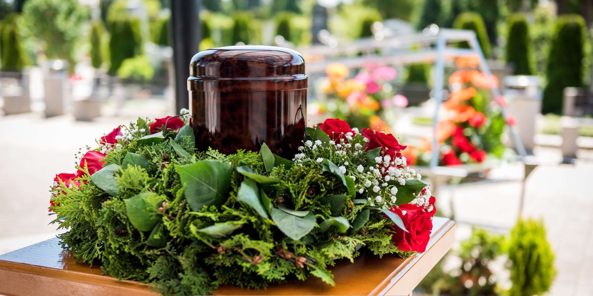 Cremation urn surrounded by floral arrangements at a memorial service, representing dignity, remembrance, and compassionate funeral home care.