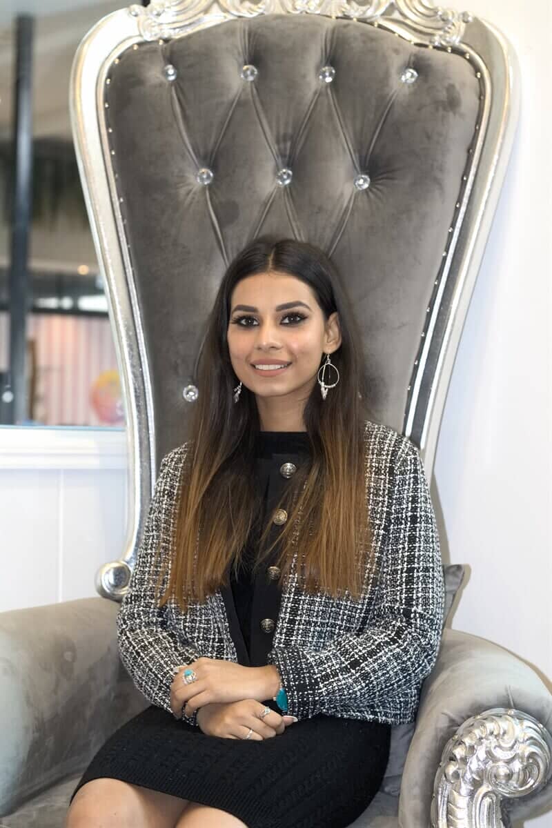 A woman is sitting in a chair with her hands folded.