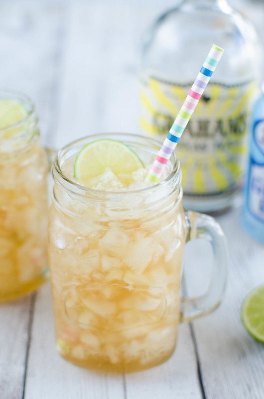 A close up of a drink in a mason jar with a straw.