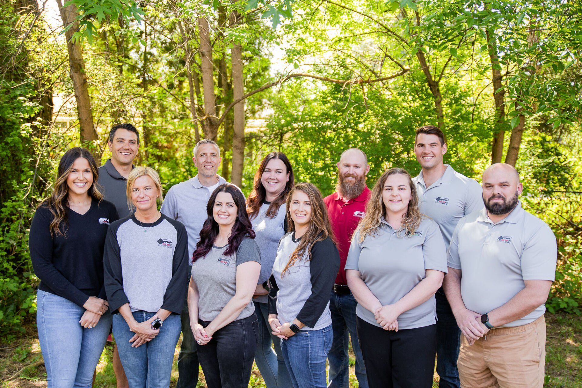 A group of people are posing for a picture in front of trees.