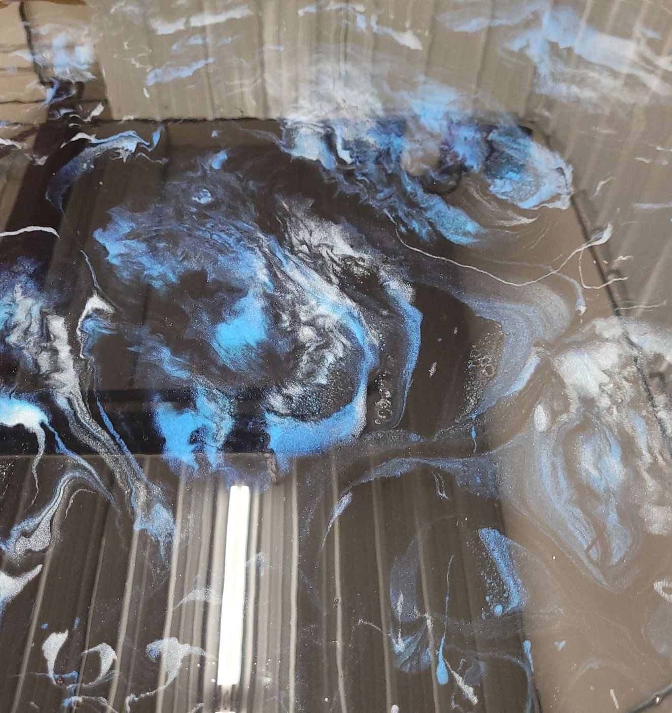 A blue and white painting on a black surface