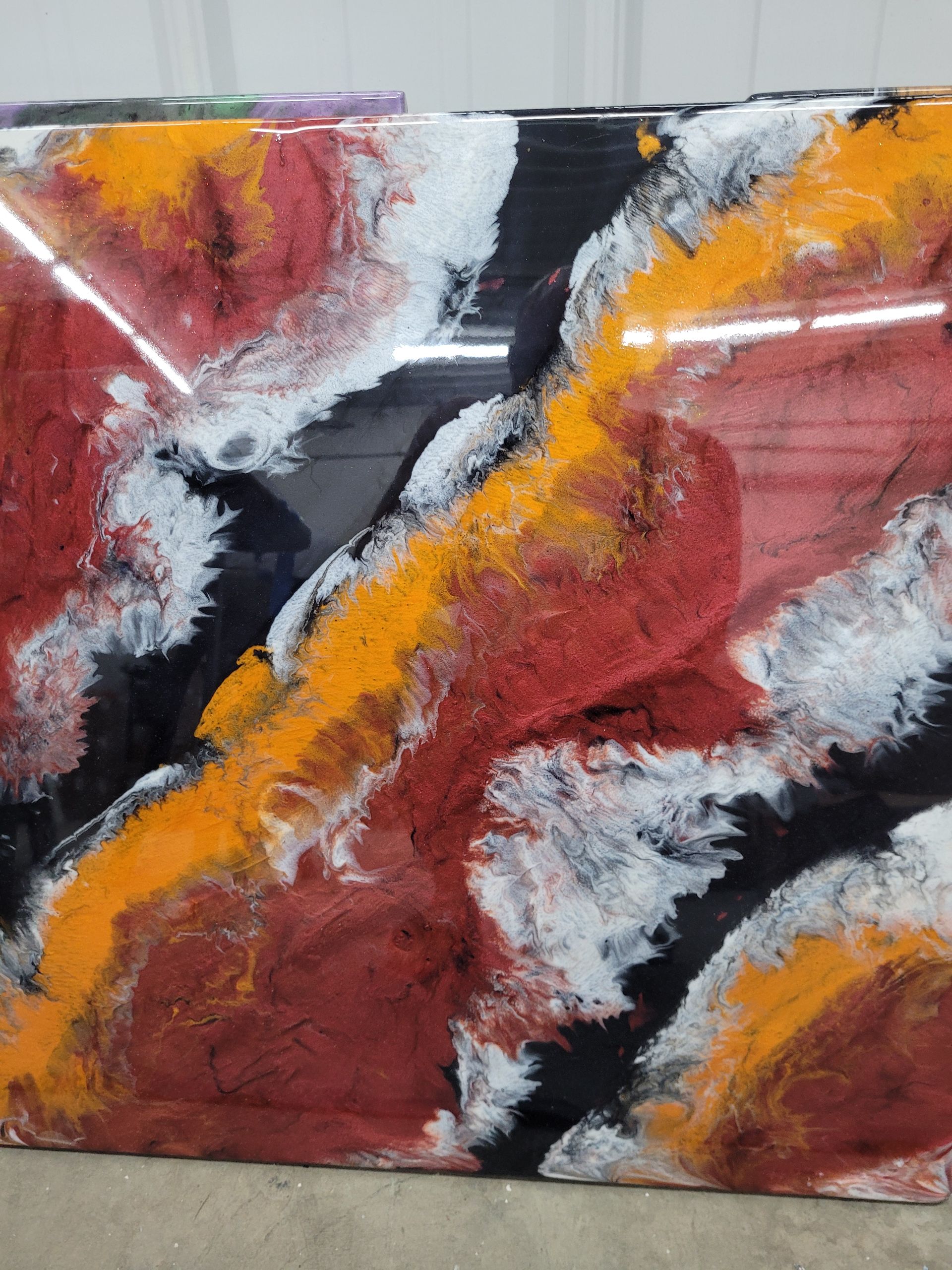 A colorful painting is sitting on a table in a room.