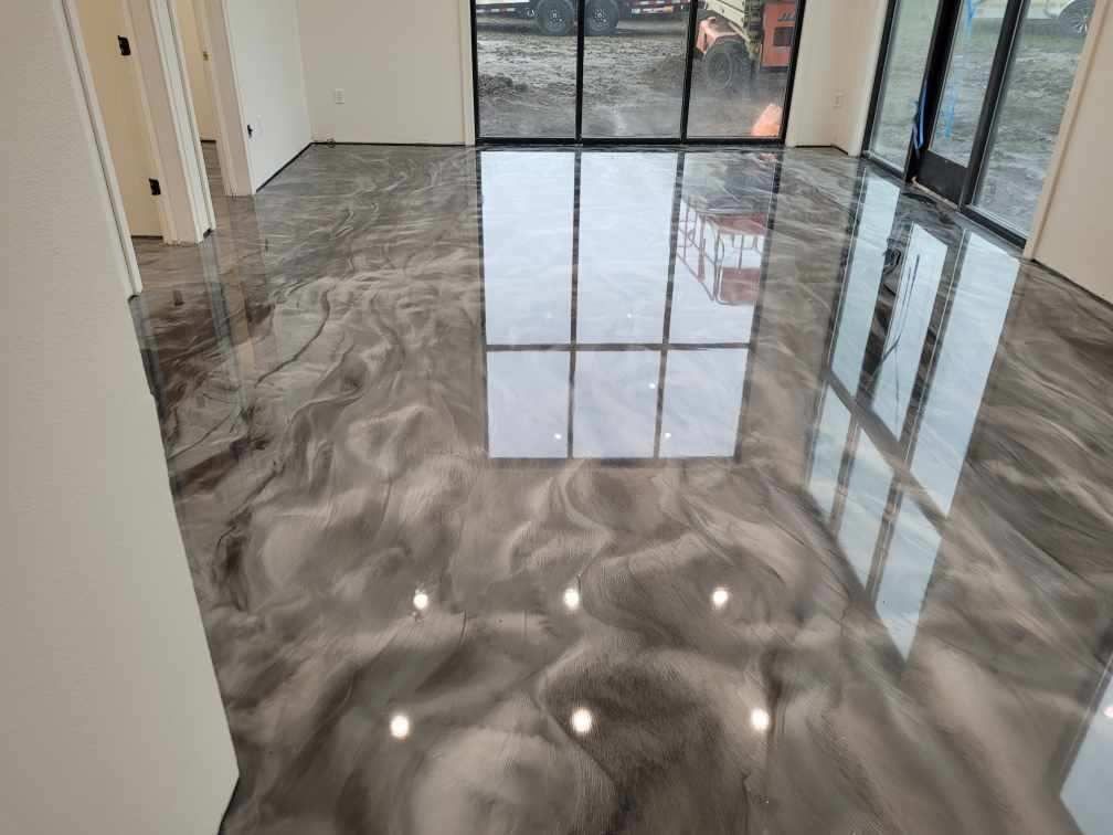 A living room with a shiny metallic floor and a large window.