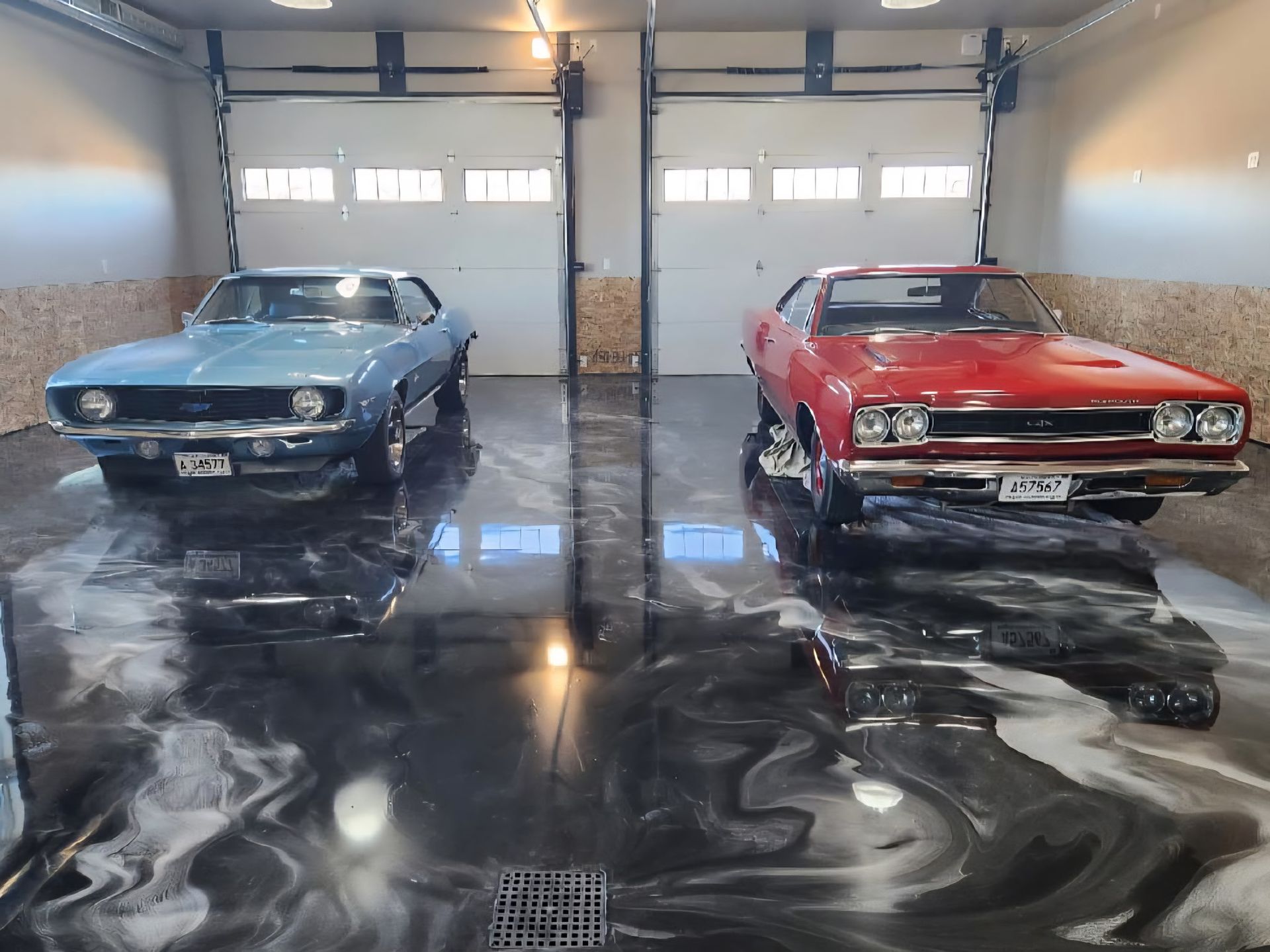 Two cars are parked next to each other in a garage.