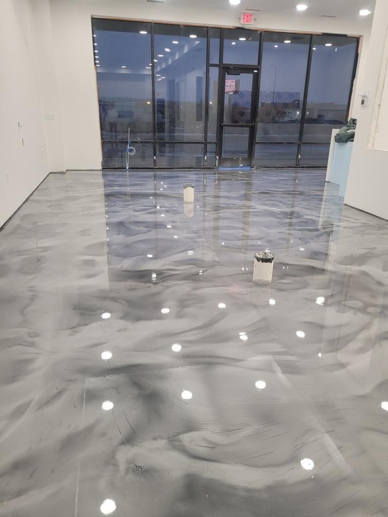 A large room with a shiny metallic floor and a large window.