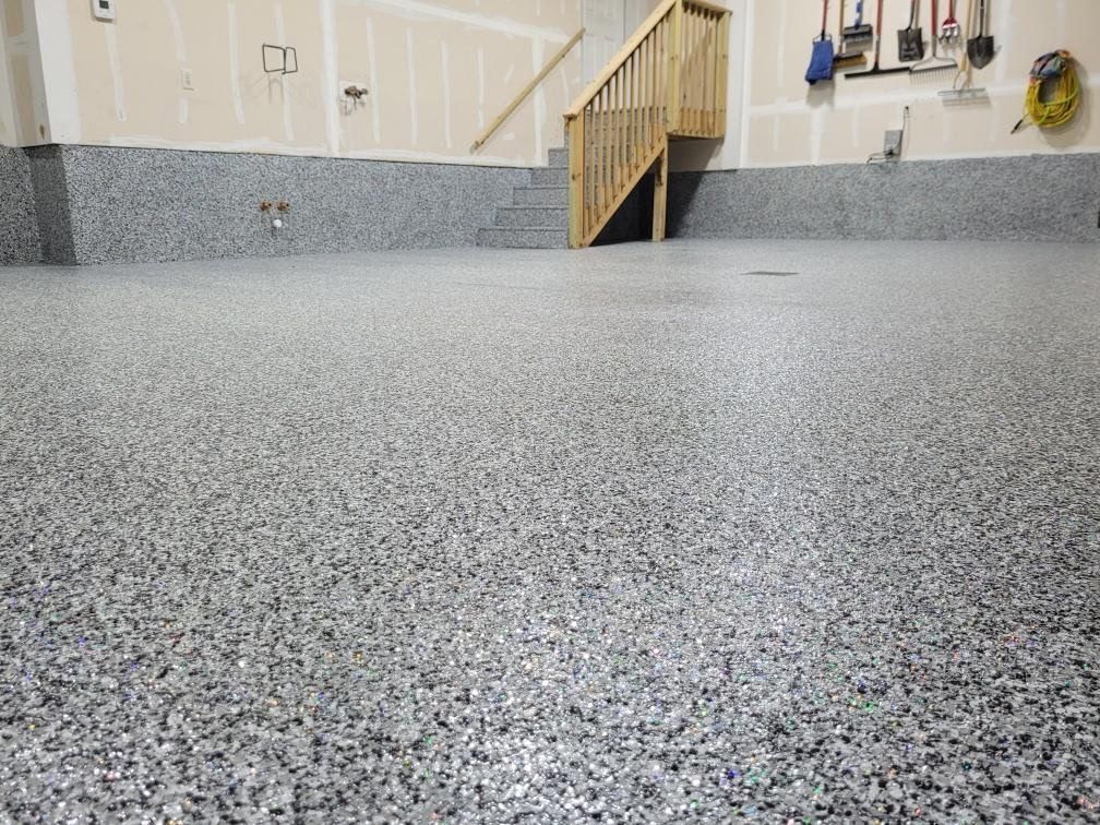 A garage with a staircase and a gray floor