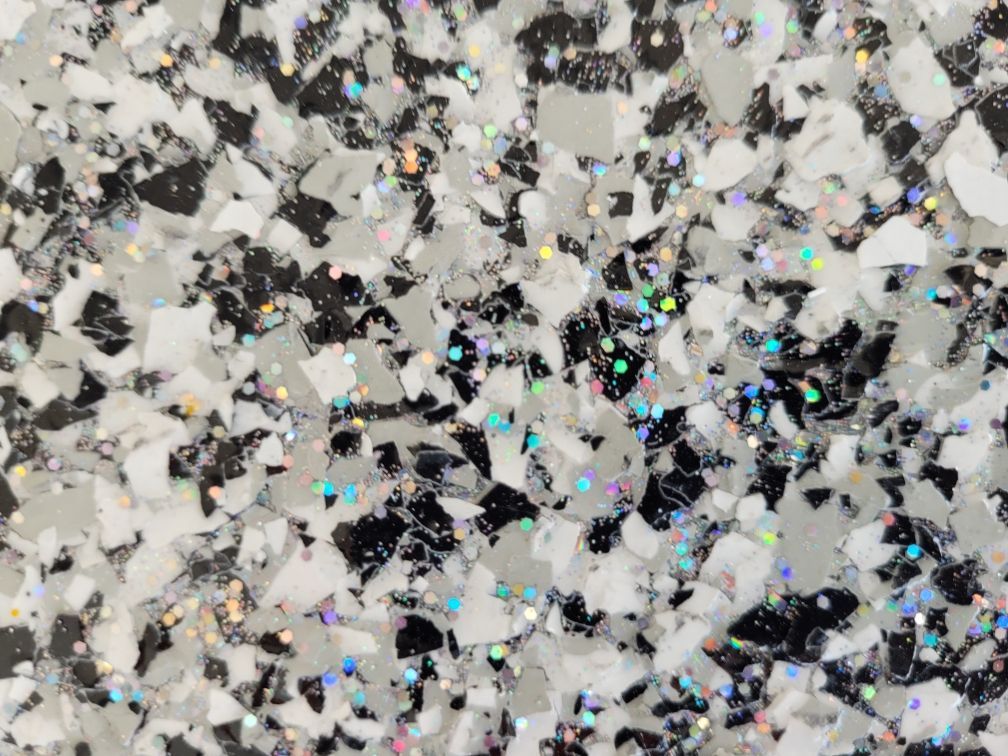 A close up of a black and white marble texture with glitter.