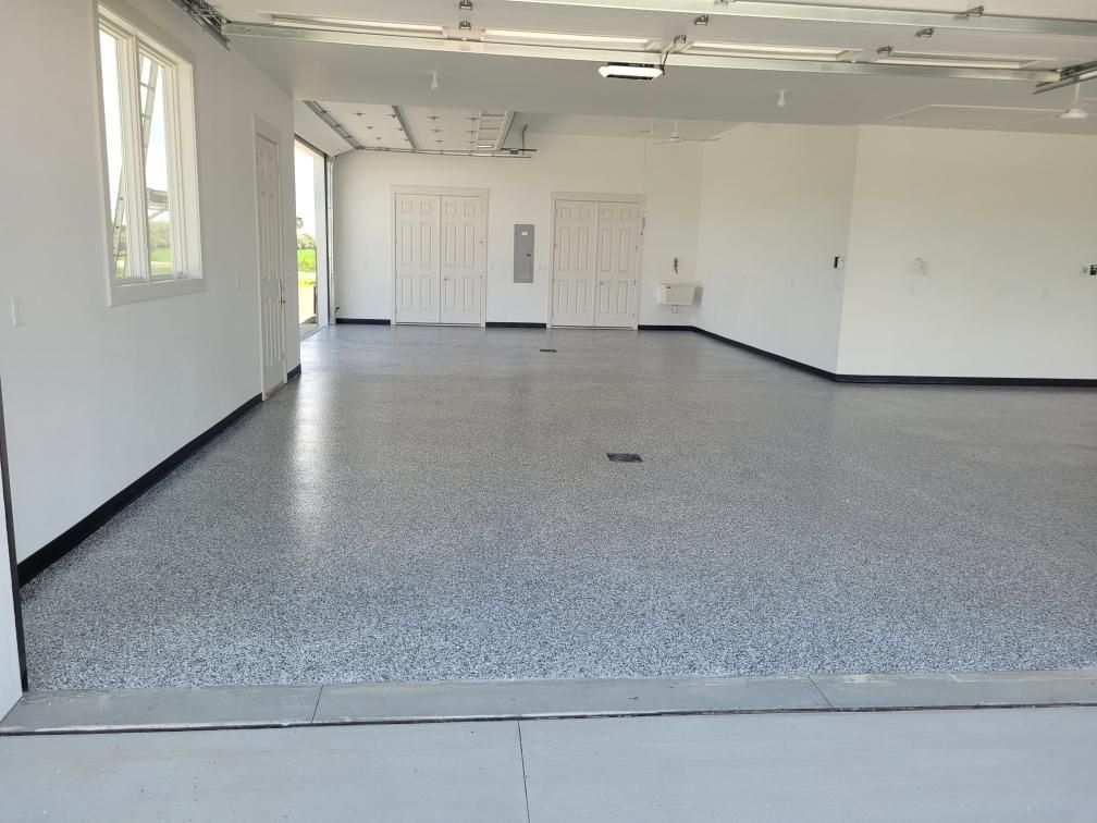 An empty garage with a gray floor and white walls