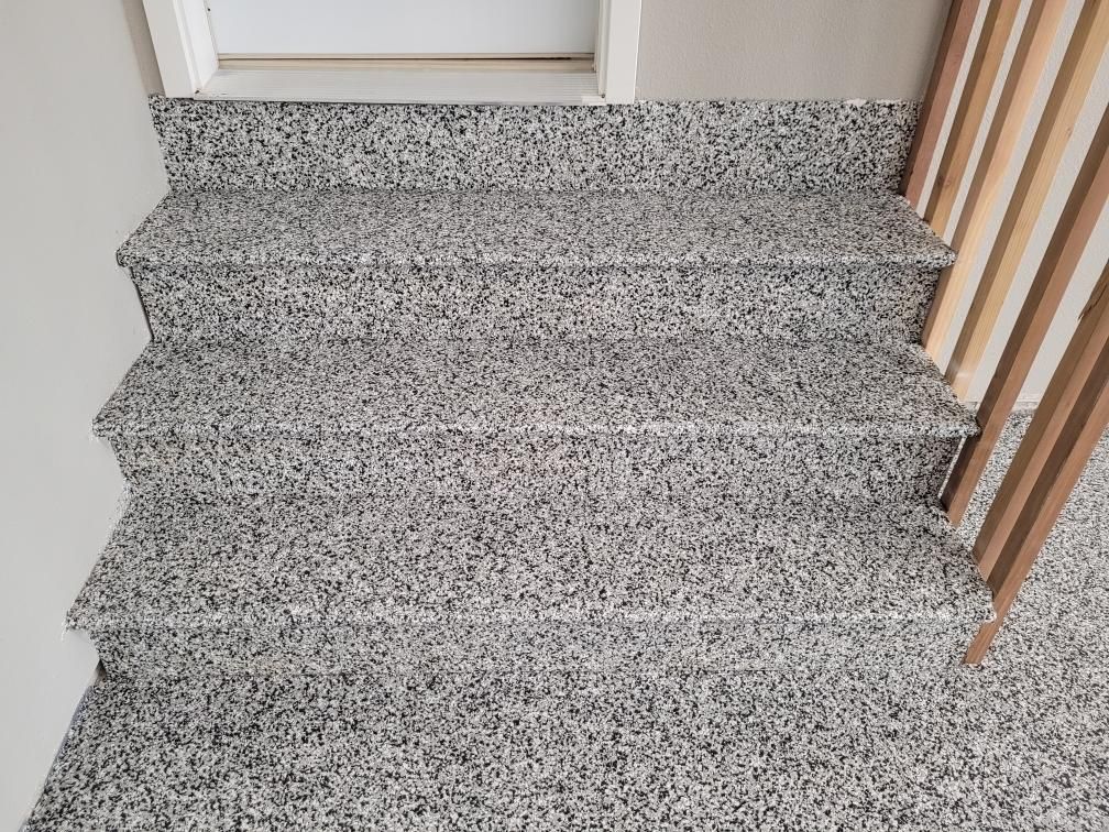 A close up of a set of stairs with a wooden railing.