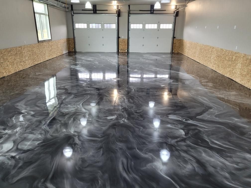A garage with a shiny metallic floor and two garage doors.