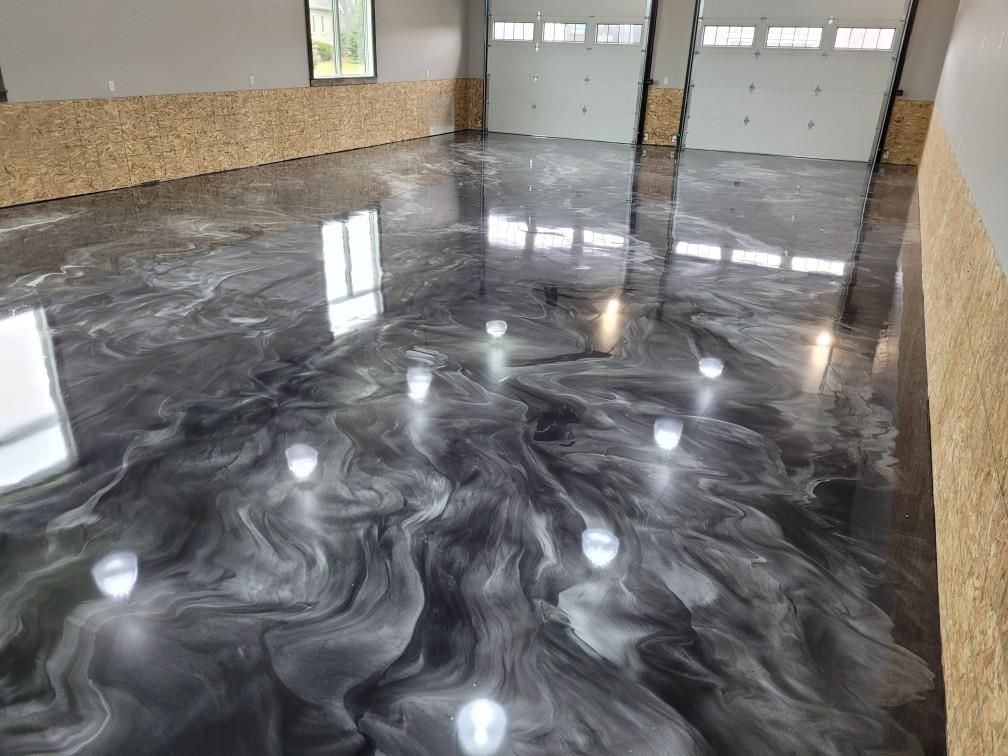A garage with a black and white epoxy floor.