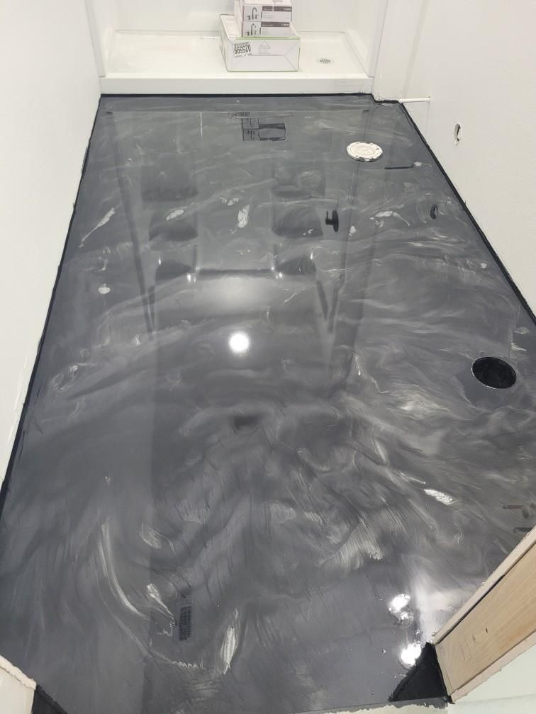 A bathroom with a metallic floor and a sink.