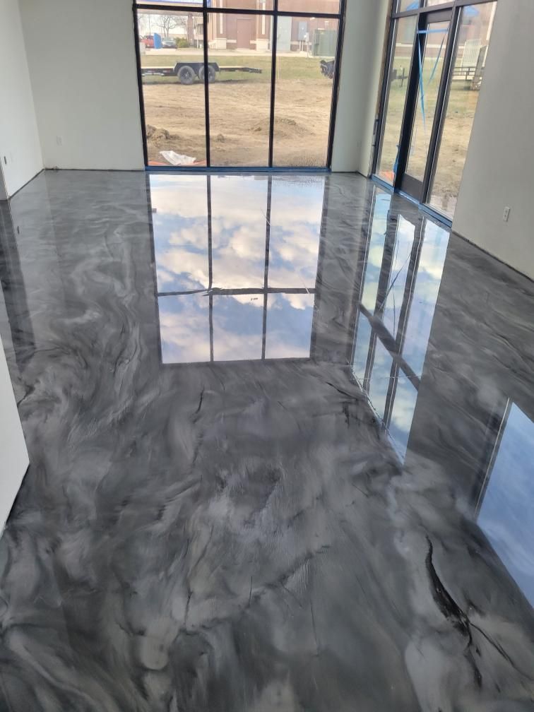 A room with a shiny metallic floor and a large window.