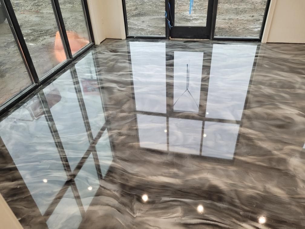 A room with a shiny metallic floor and a lot of windows.