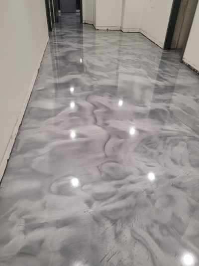 A hallway with a shiny metallic floor in a building.