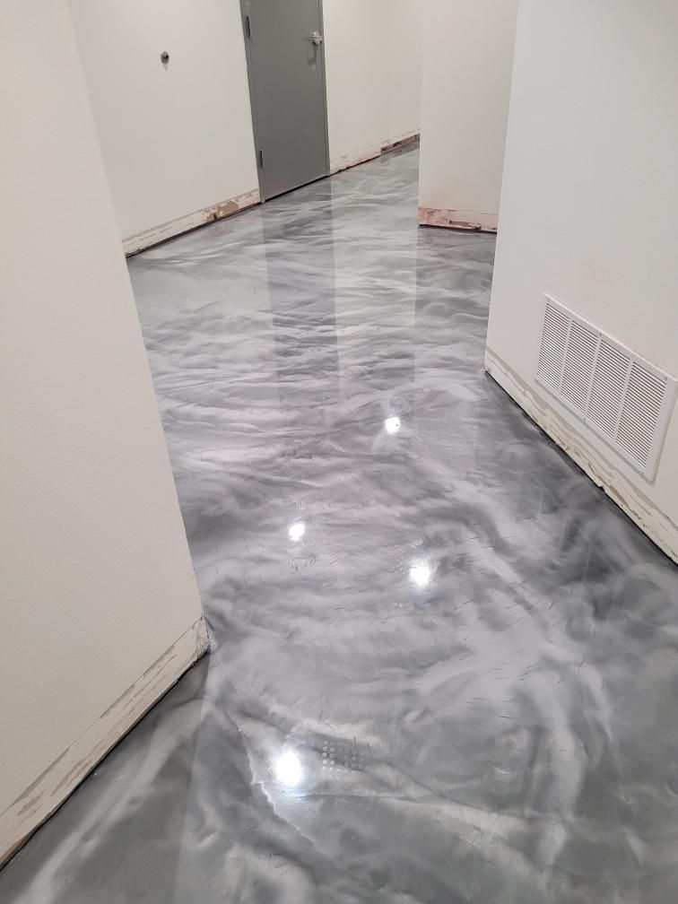 A hallway with a gray and white metallic floor.