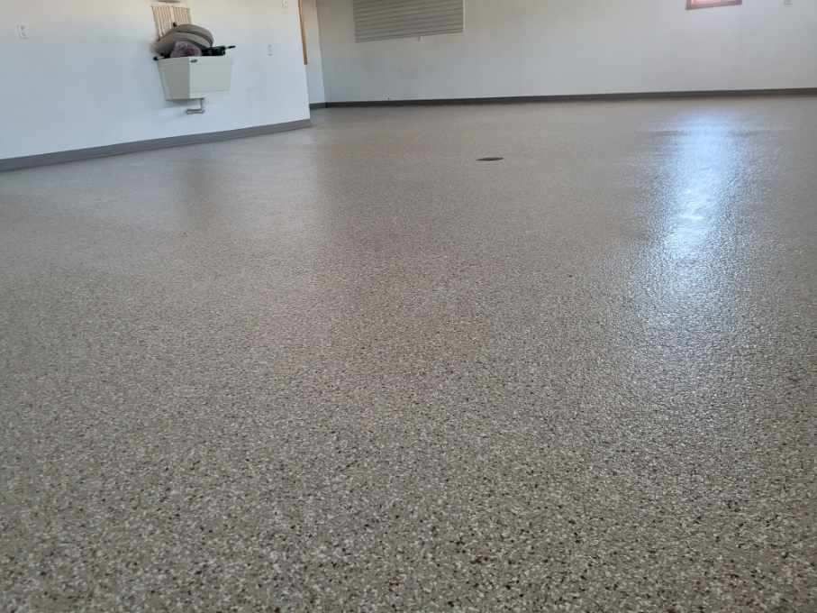 A large empty room with a concrete floor and white walls.
