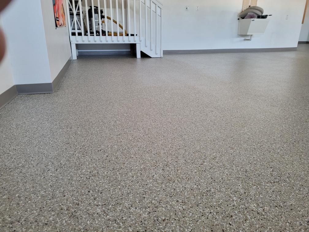A room with a staircase and a concrete floor.
