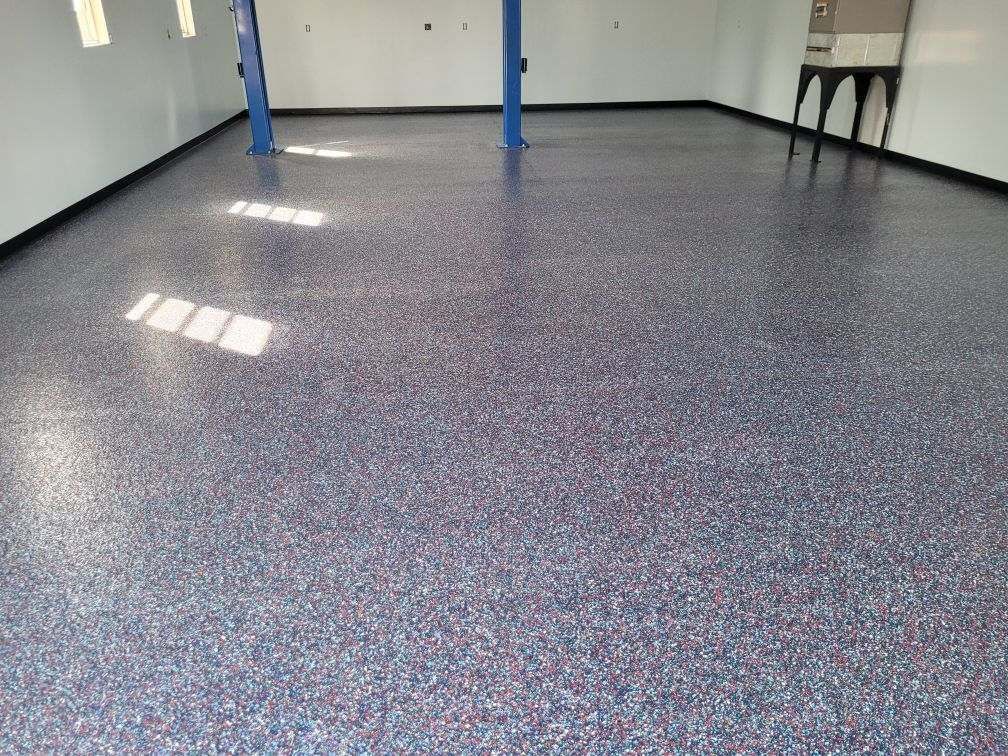 A garage with a purple floor and a blue lift.