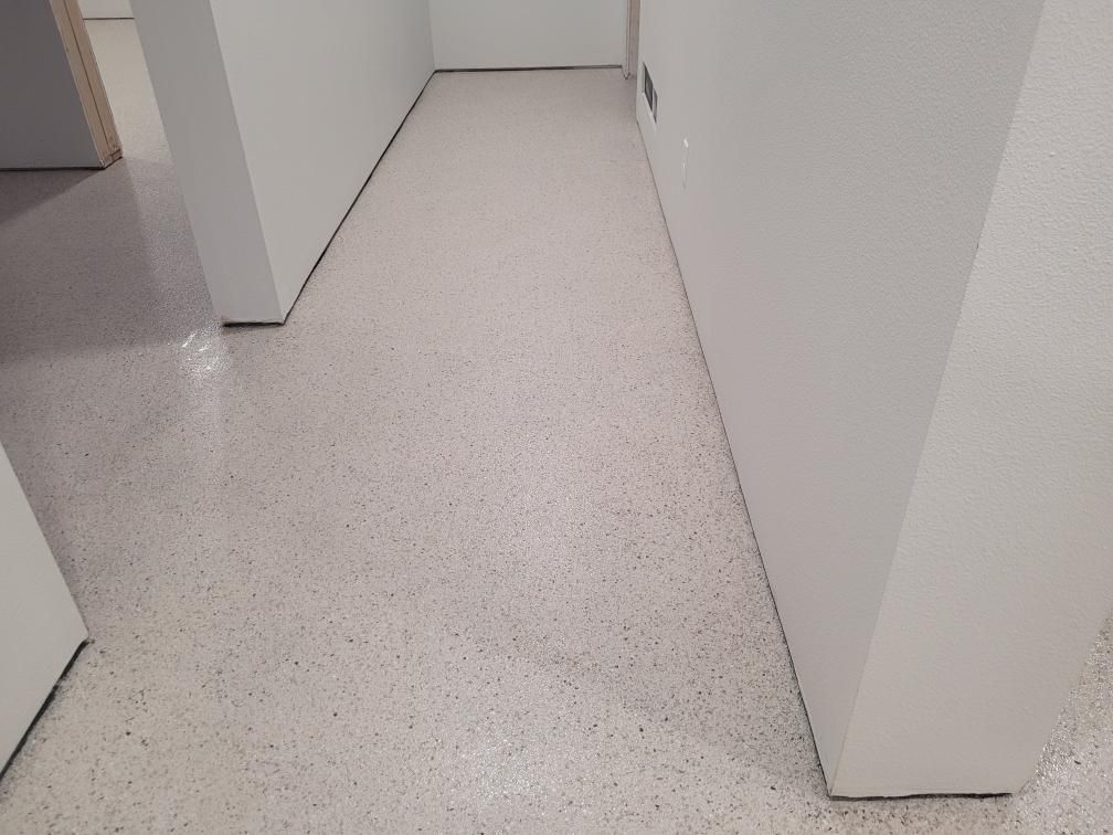 A hallway with a white floor and white walls.