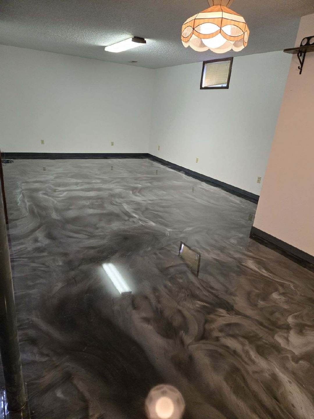 A living room with a marble floor and a chandelier hanging from the ceiling.