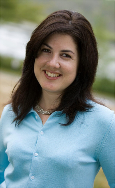 A woman in a blue shirt is smiling for the camera