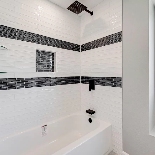 A bathroom with a bathtub and a shower head.