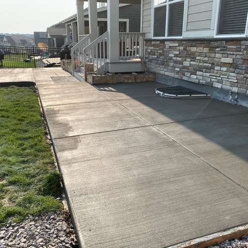 A concrete walkway leading to the front of a house.