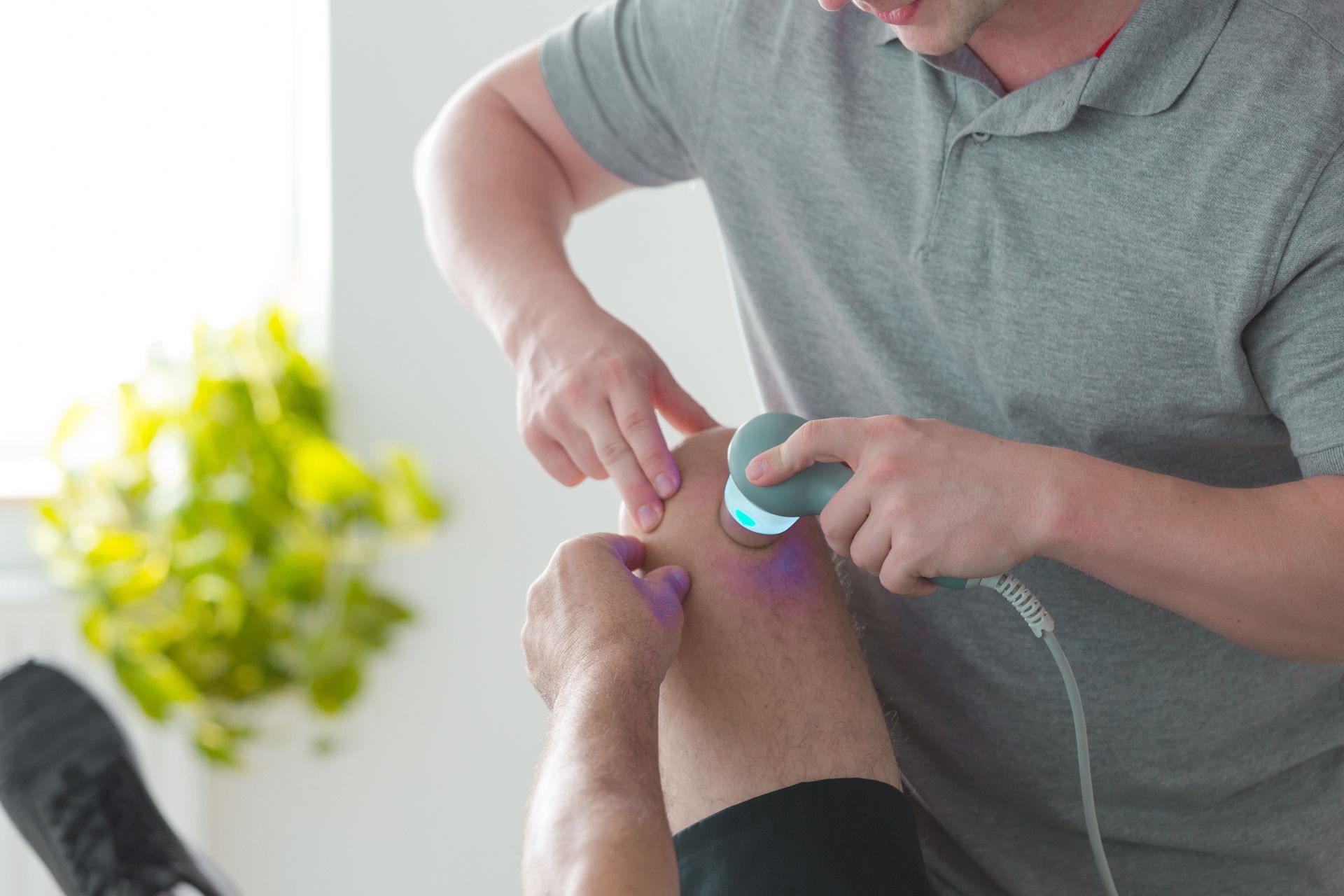 A person is using a device on their elbow — Monroe, LA — Coleman Chiropractic Clinic