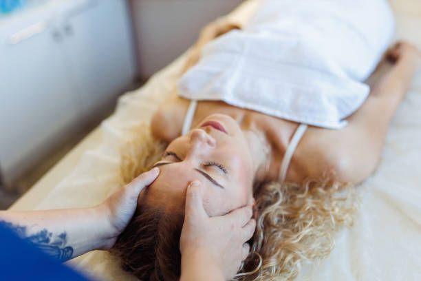 A woman is laying on a bed getting a head massage — Monroe, LA — Coleman Chiropractic Clinic