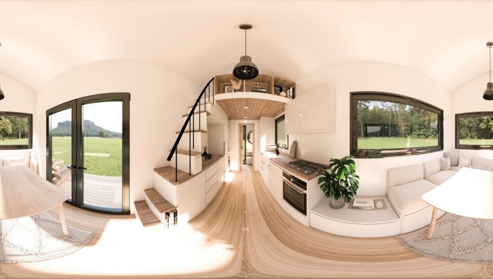 360-degree view of tiny home interior. White walls, wood floor, kitchen, stairs, sofa, windows, and outdoor views.