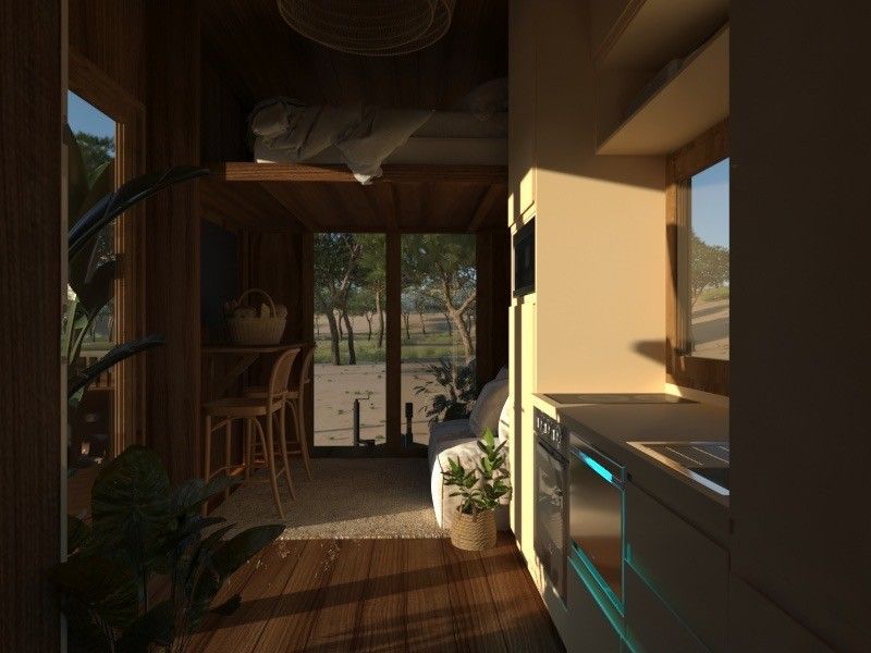 Interior view of a small cabin with wooden walls, a kitchen, and a view of nature through a door.