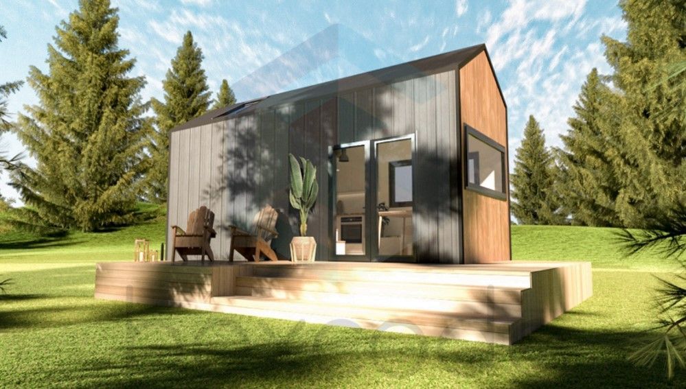 Modern tiny house with wood and dark metal siding on a wooden deck, set in a grassy area with trees.
