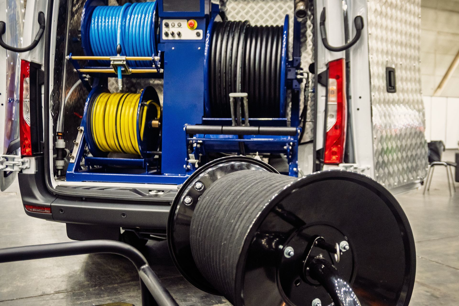 Van interior with blue, yellow, and black hose reels.