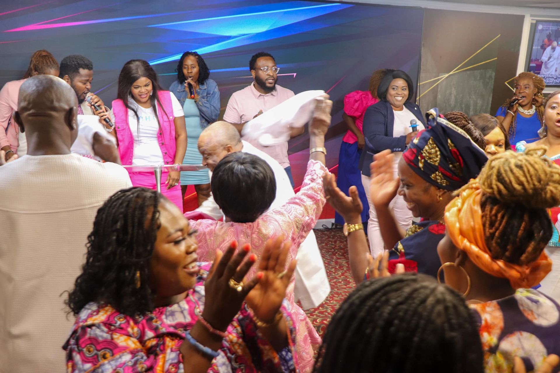 People clapping and celebrating in a church with a live band.