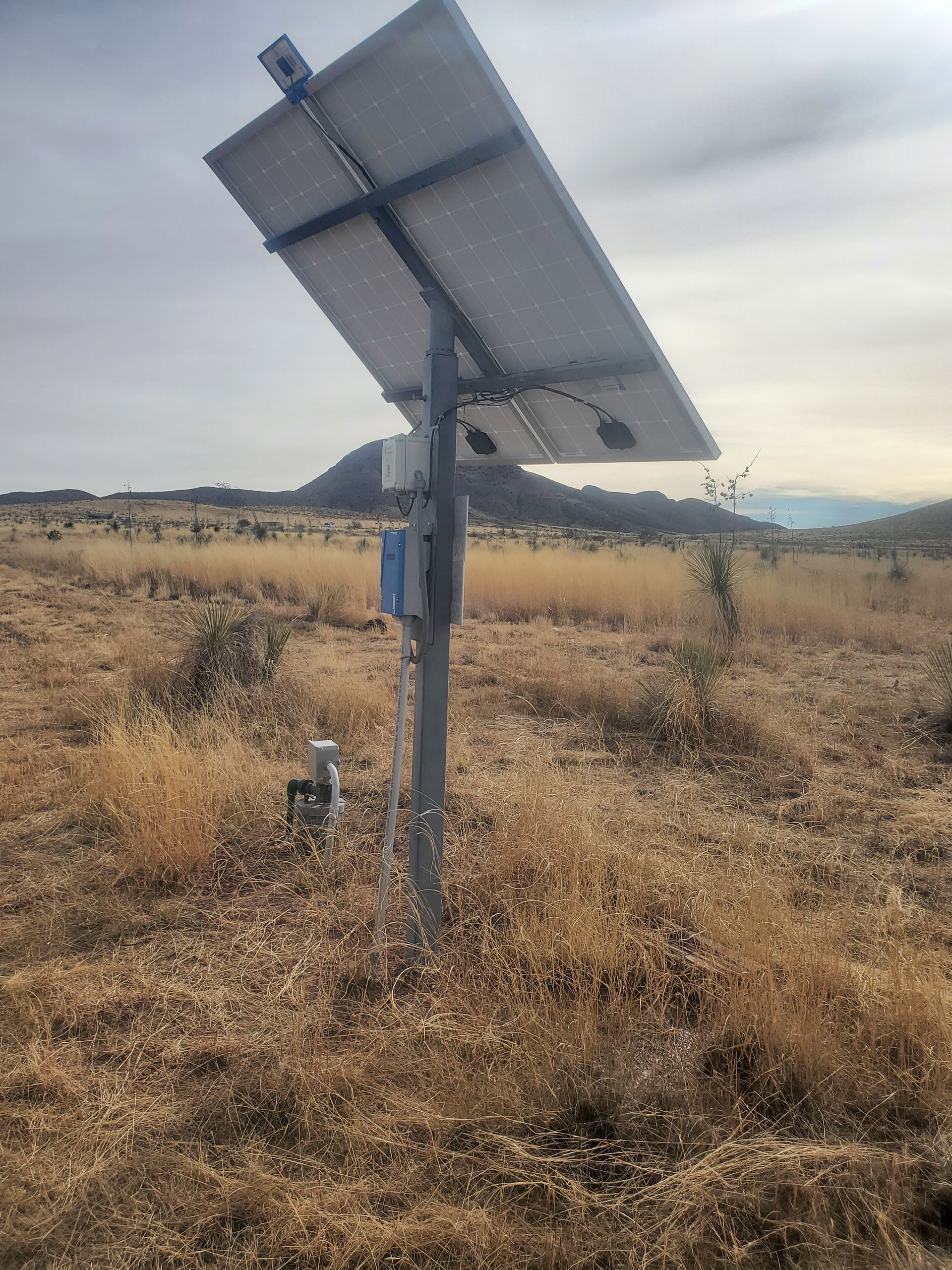 a solar panel is sitting in the middle of a field .