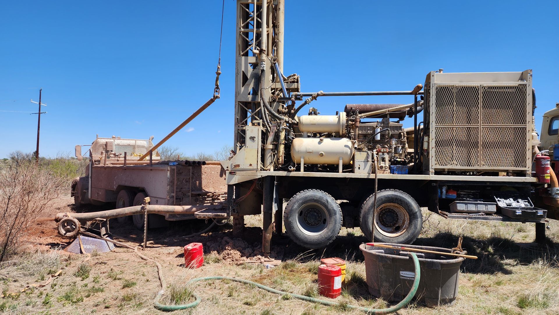 a truck with a drilling rig attached to it is in a field .