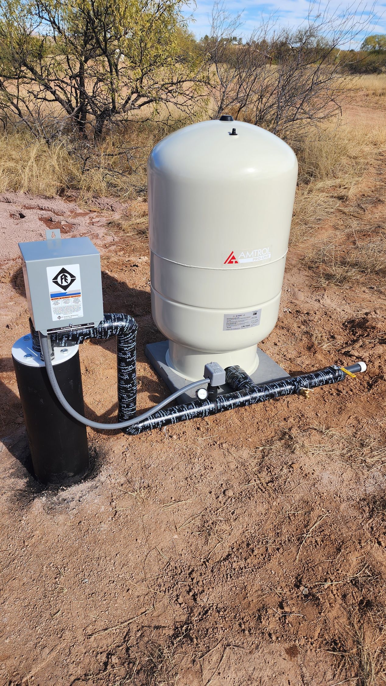 a water pump is sitting in the middle of a field .