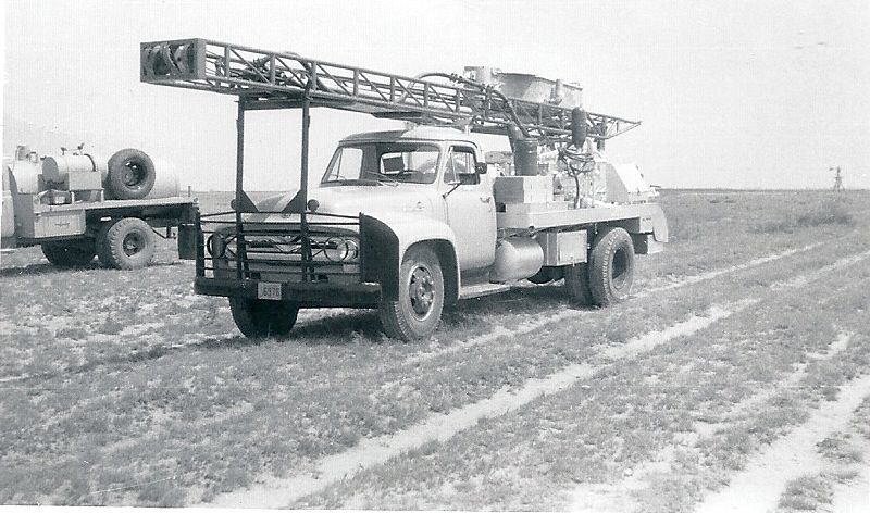 a black and white photo of a truck with a ladder on top of it