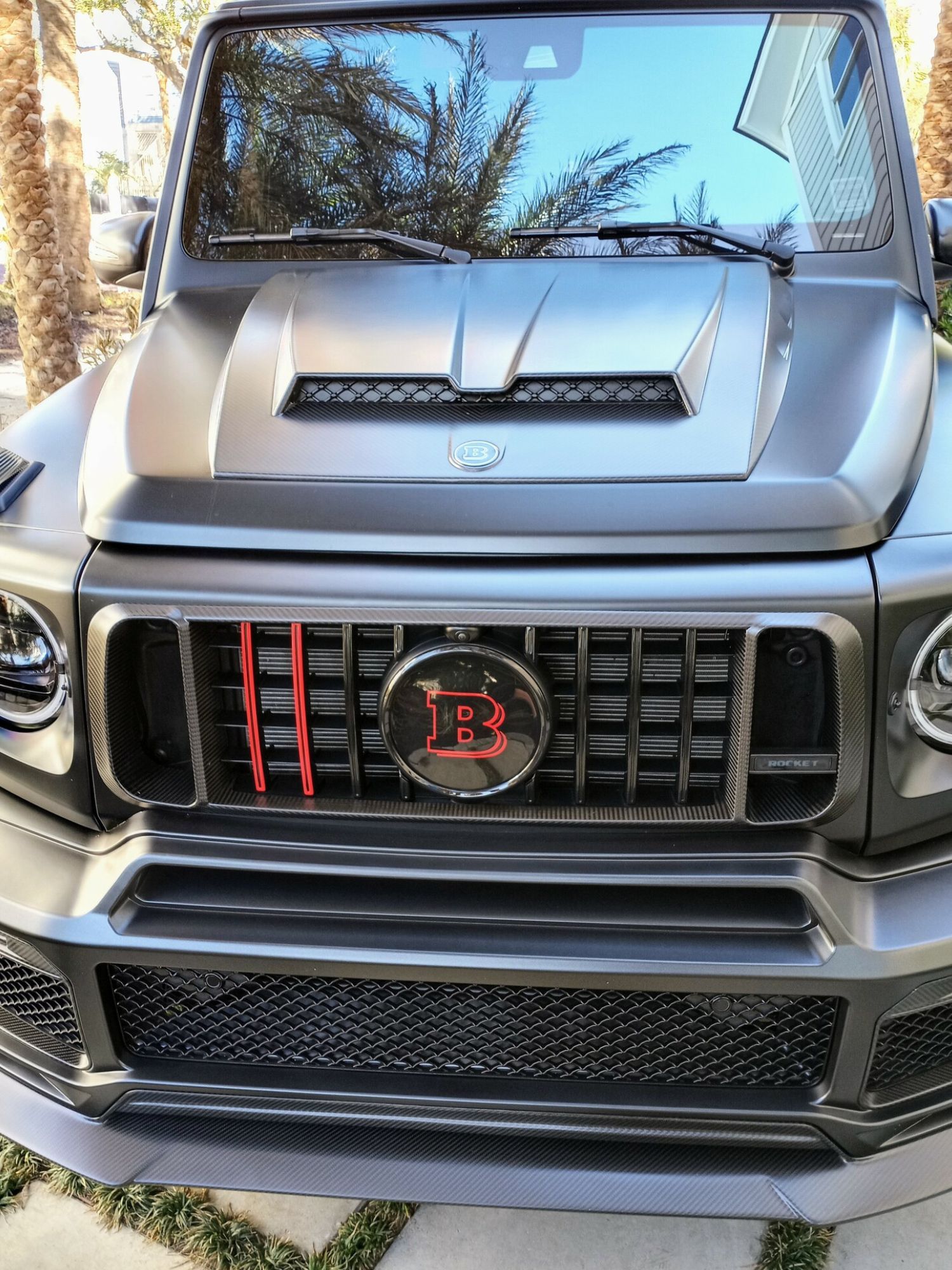 A mercedes benz g63 is parked in a driveway.