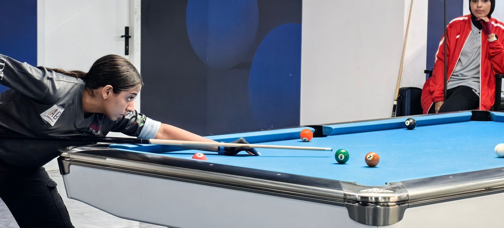 A woman is playing pool