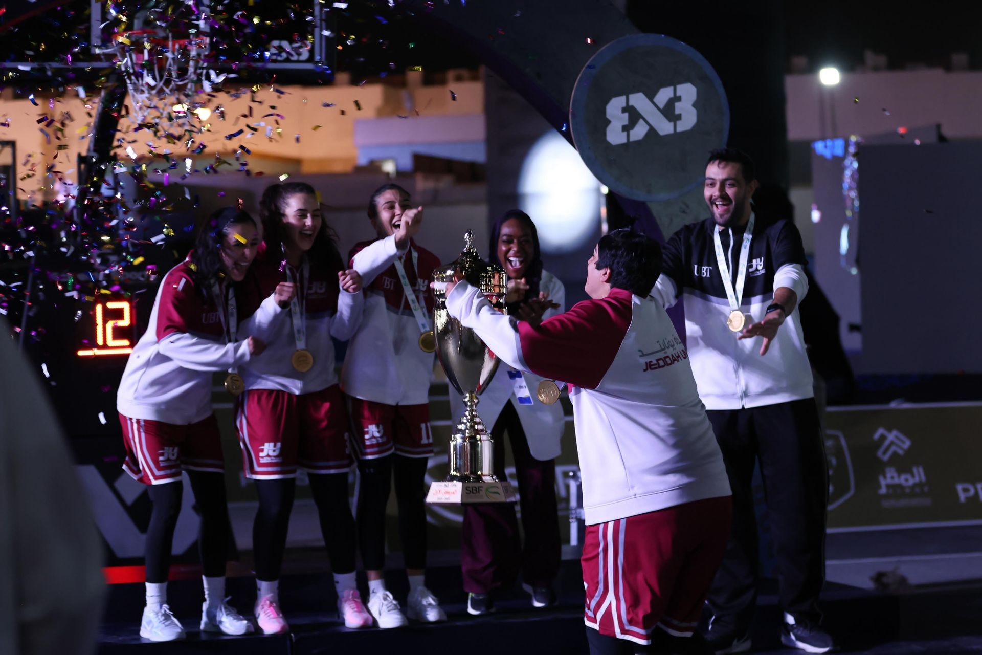 A group of people are standing on a stage holding a trophy.
