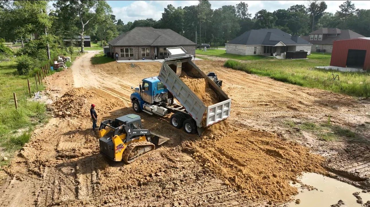 Fallen tree blocking a residential street; exposed roots, green branches, and debris litter the asphalt.