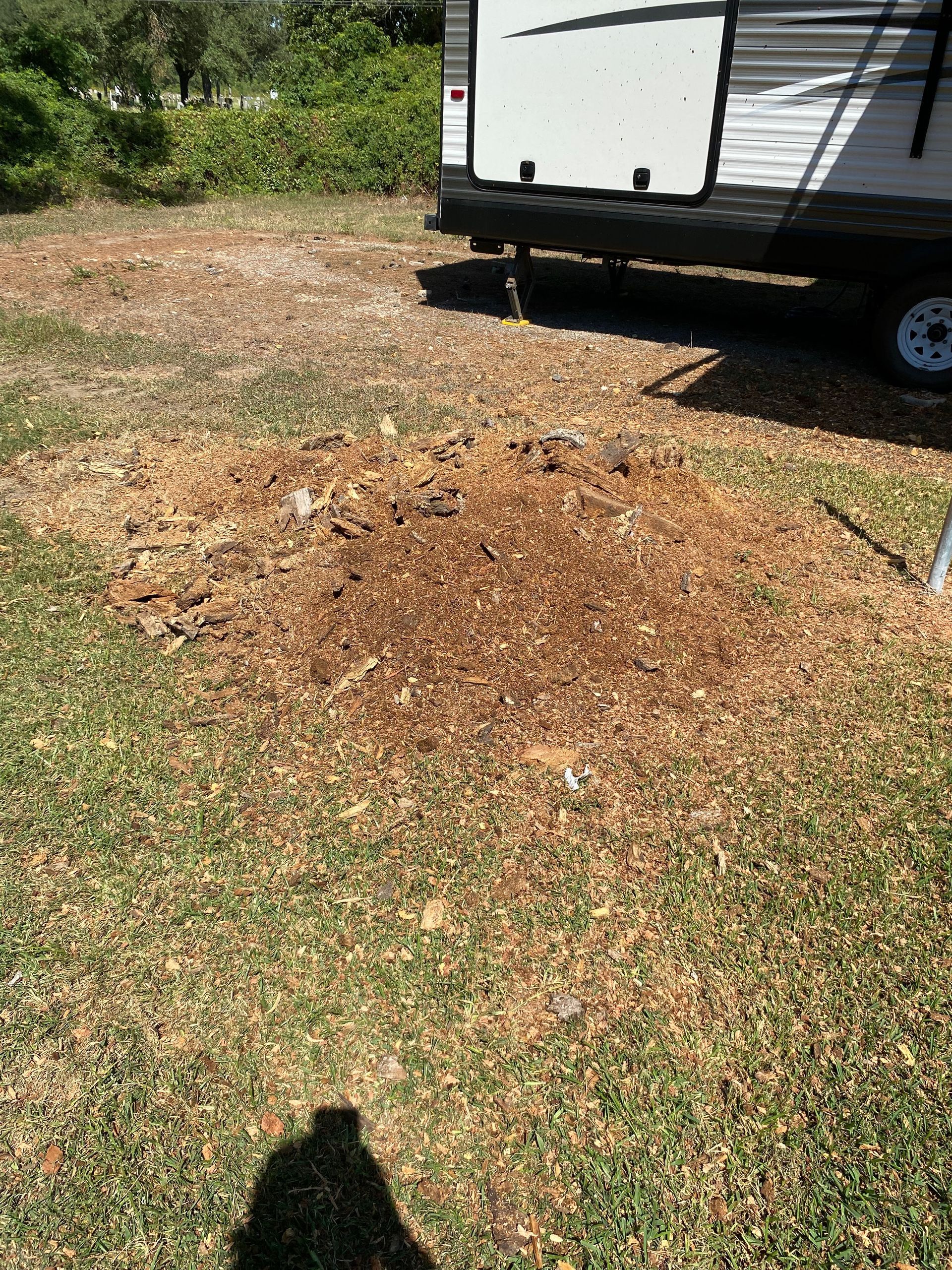 Brown mulch patch in grass near the side of a camper.