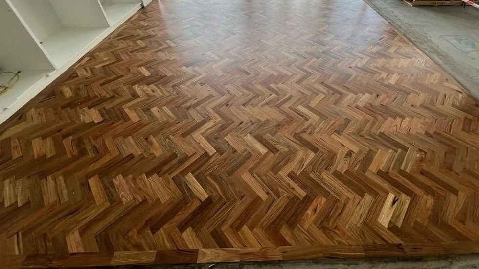 A Large Wooden Floor With a Herringbone Pattern in a Room — Timberfection Queensland in Yatala, QLD