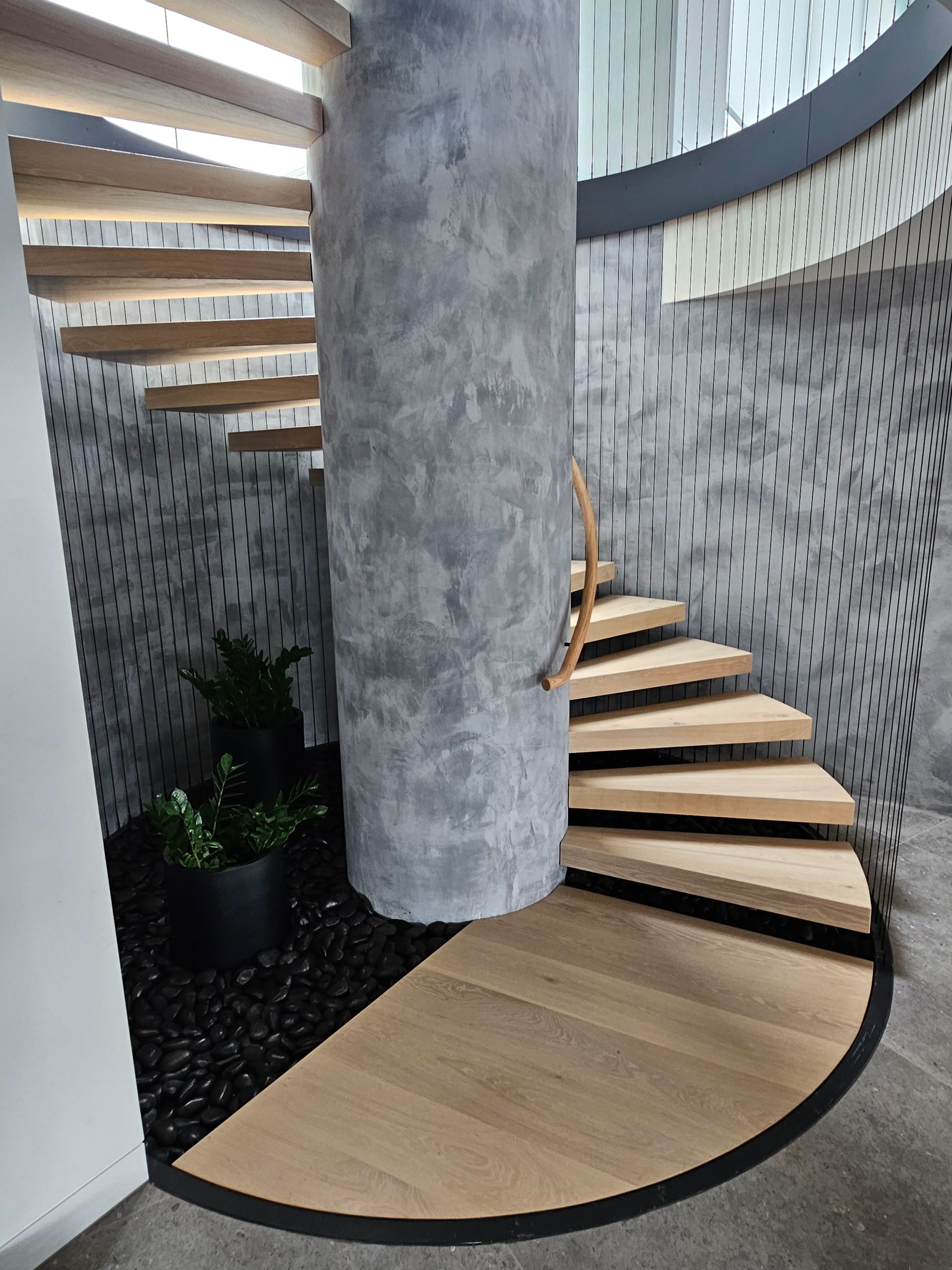 A Long Hallway With Hardwood Floors and White Walls Leading to a Living Room — Timberfection Queensland in Yatala, QLD