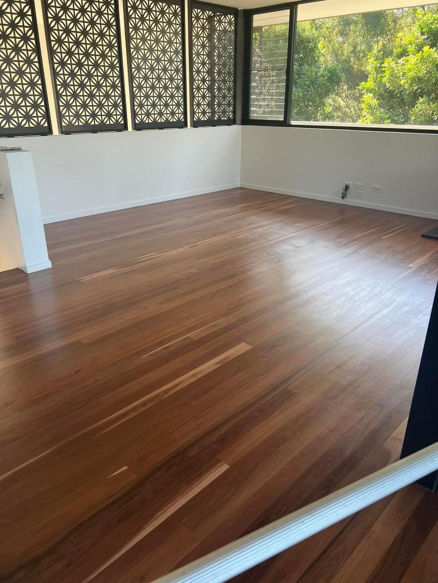 A Large Empty Room With a Wooden Floor and a Lot of Windows — Timberfection Queensland in Yatala, QLD