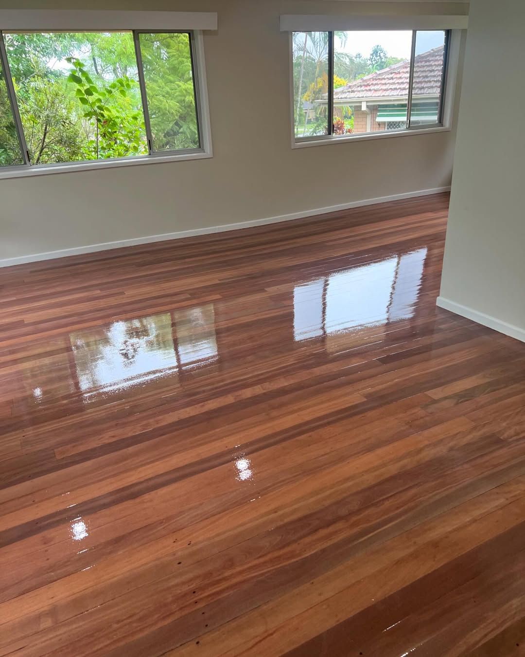 A Living Room With a Wooden Floor and Two Windows — Timberfection Queensland in Yatala, QLD